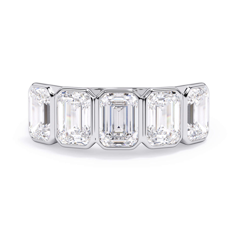 A picture of a five stone diamond wedding ring with emerald cut diamonds that are bezel set in white gold or platinum on a white background with the ring facing forward, lying down.