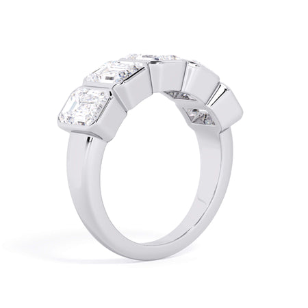 A picture of a five stone diamond wedding ring with emerald cut diamonds that are bezel set in white gold or platinum on a white background with a slightly angled, through the finger view.