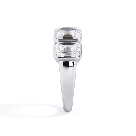 A picture of a five stone diamond wedding ring with emerald cut diamonds that are bezel set in white gold or platinum on a white background with a side profile view.