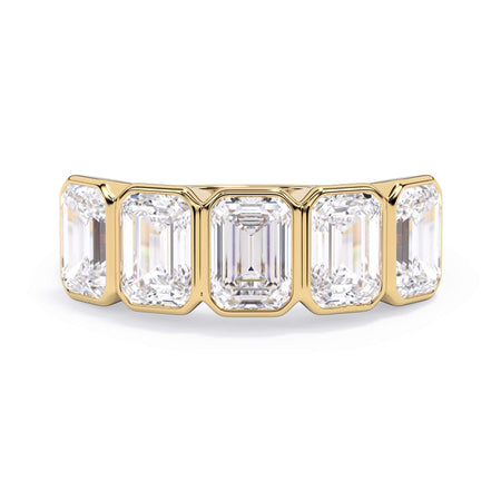 A picture of a five stone diamond wedding ring with emerald cut diamonds that are bezel set in yellow gold on a white background with the ring facing forward, lying down.