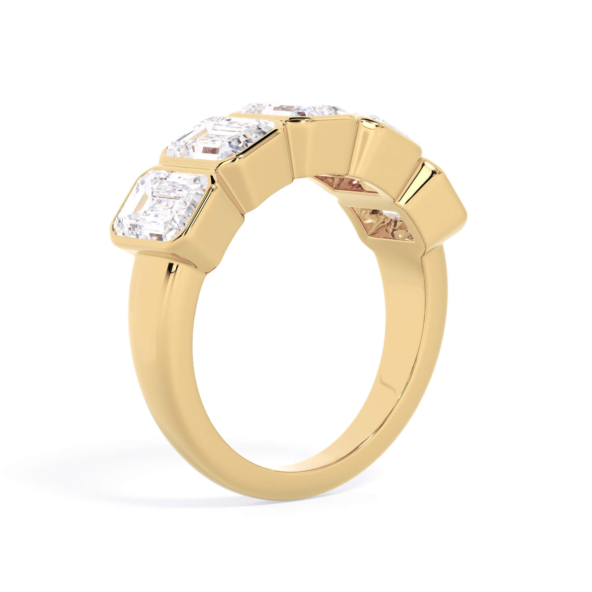 A picture of a five stone diamond wedding ring with emerald cut diamonds that are bezel set in yellow gold on a white background with a slightly angled, through the finger view.