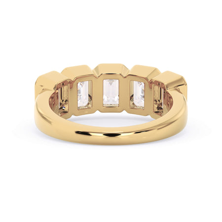 A picture of a five stone diamond wedding ring with emerald cut diamonds that are bezel set in yellow gold on a white background with a view of the underside of the ring.