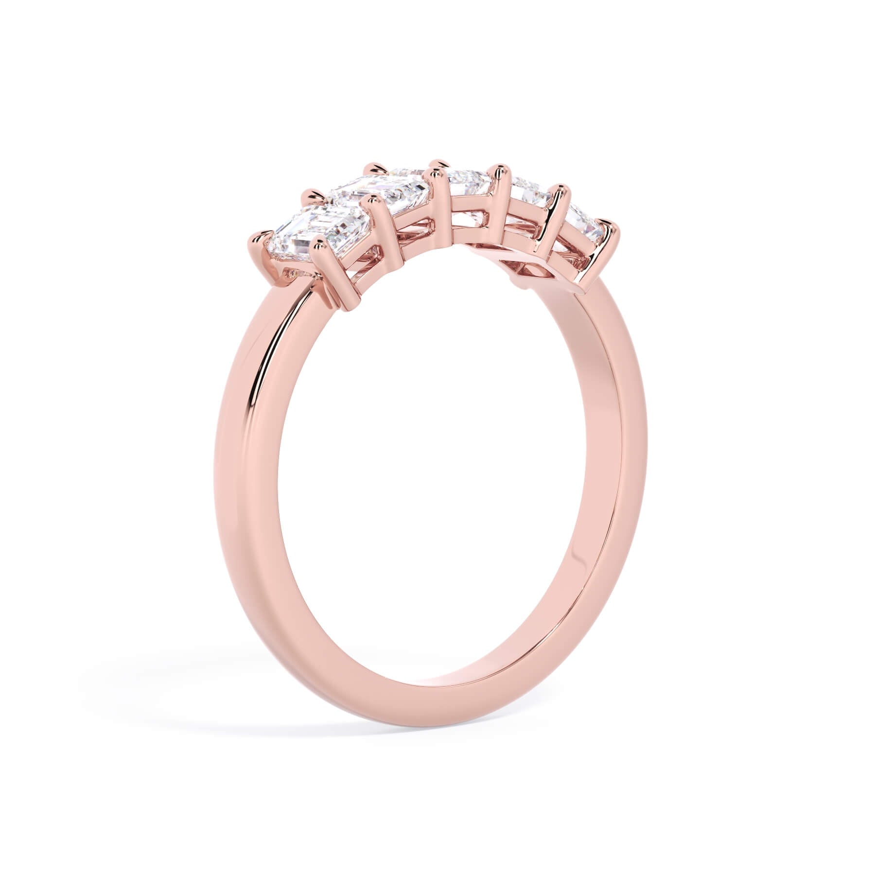 A picture of a five stone diamond wedding ring with emerald cut diamonds that are shared prong set in rose gold on a white background with a slightly angled, through the finger view.