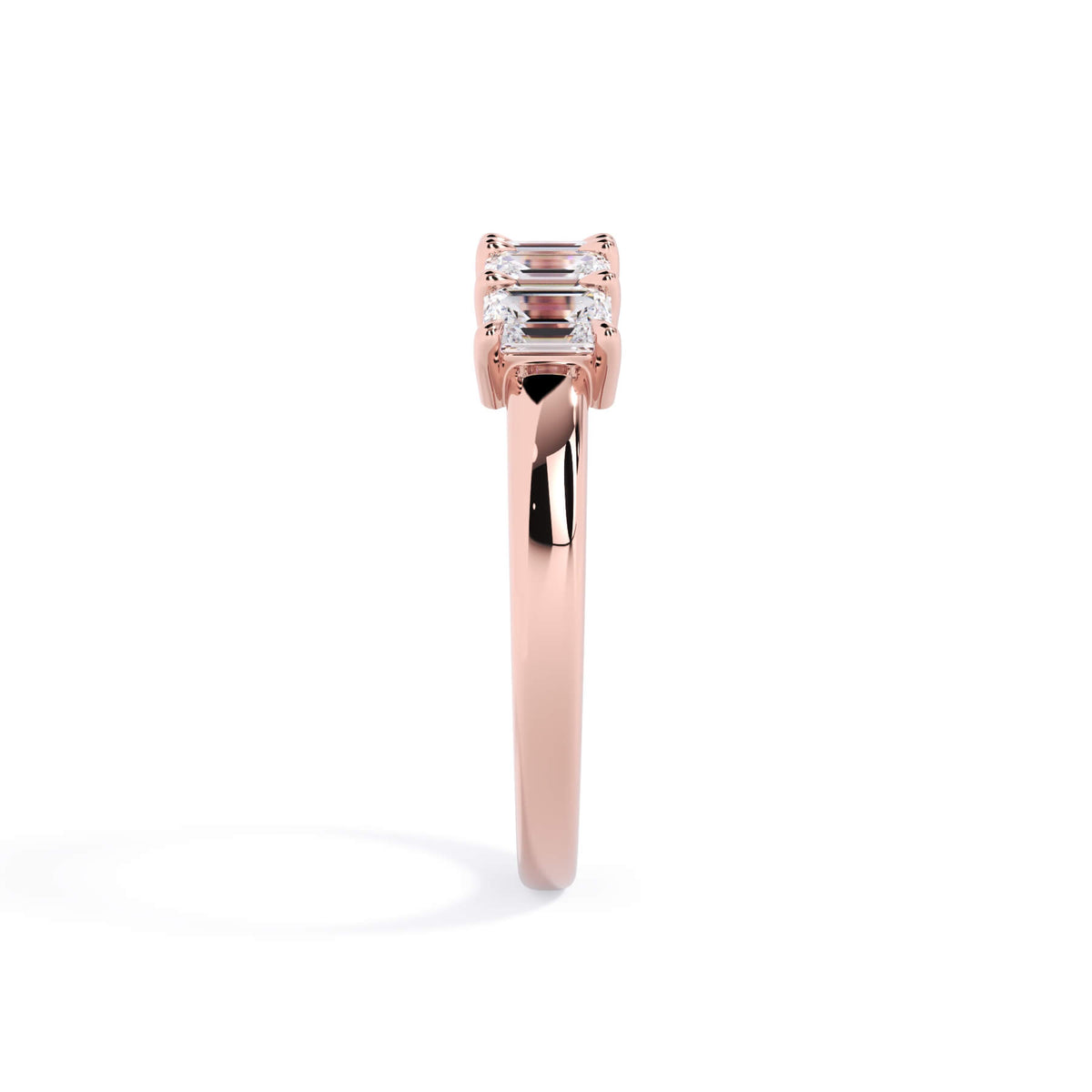 A picture of a five stone diamond wedding ring with emerald cut diamonds that are shared prong set in rose gold on a white background with a side profile view.
