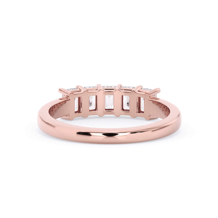 A picture of a five stone diamond wedding ring with emerald cut diamonds that are shared prong set in rose gold on a white background with a view of the underside of the ring.
