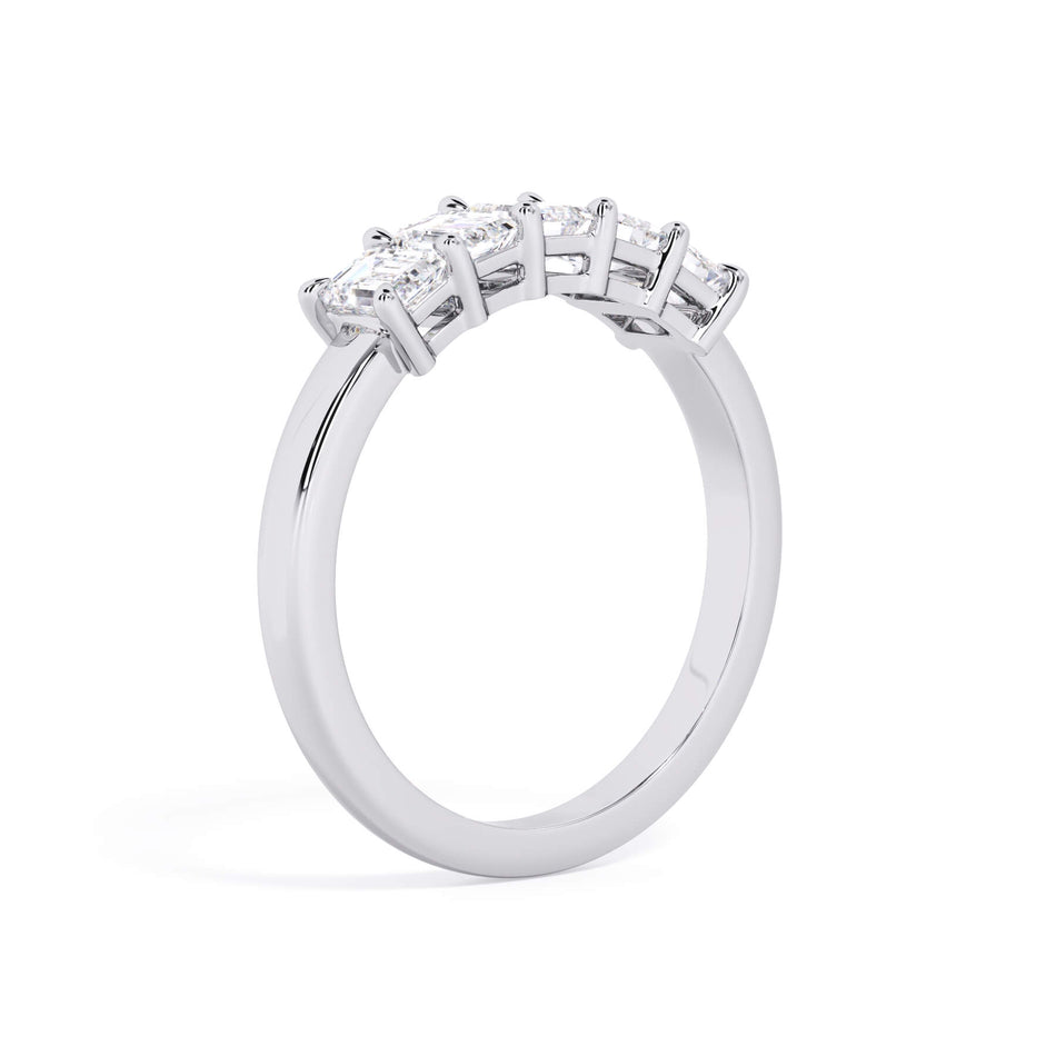 A picture of a five stone diamond wedding ring with emerald cut diamonds that are shared prong set in white gold or platinum on a white background with a slightly angled, through the finger view.