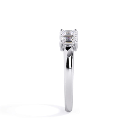 A picture of a five stone diamond wedding ring with emerald cut diamonds that are shared prong set in white gold or platinum on a white background with a side profile view.