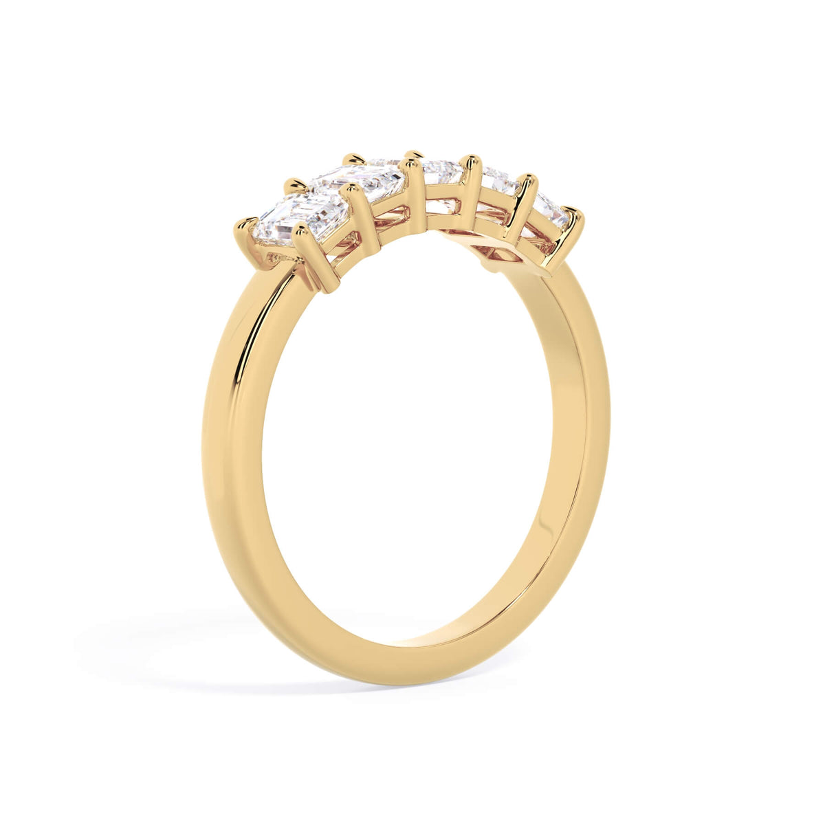 A picture of a five stone diamond wedding ring with emerald cut diamonds that are shared prong set in yellow gold on a white background with a slightly angled, through the finger view.