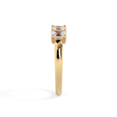 A picture of a five stone diamond wedding ring with emerald cut diamonds that are shared prong set in yellow gold on a white background with a side profile view.