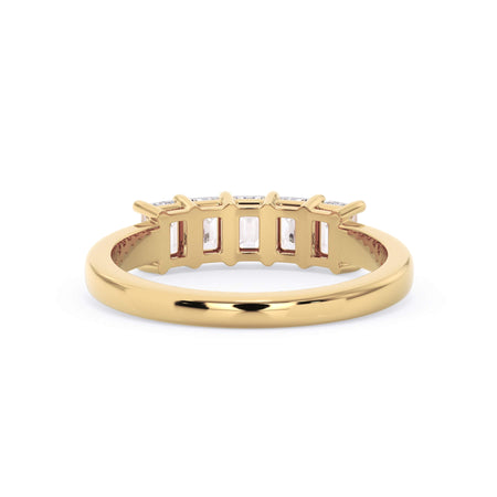 A picture of a five stone diamond wedding ring with emerald cut diamonds that are shared prong set in yellow gold on a white background with a view of the underside of the ring.