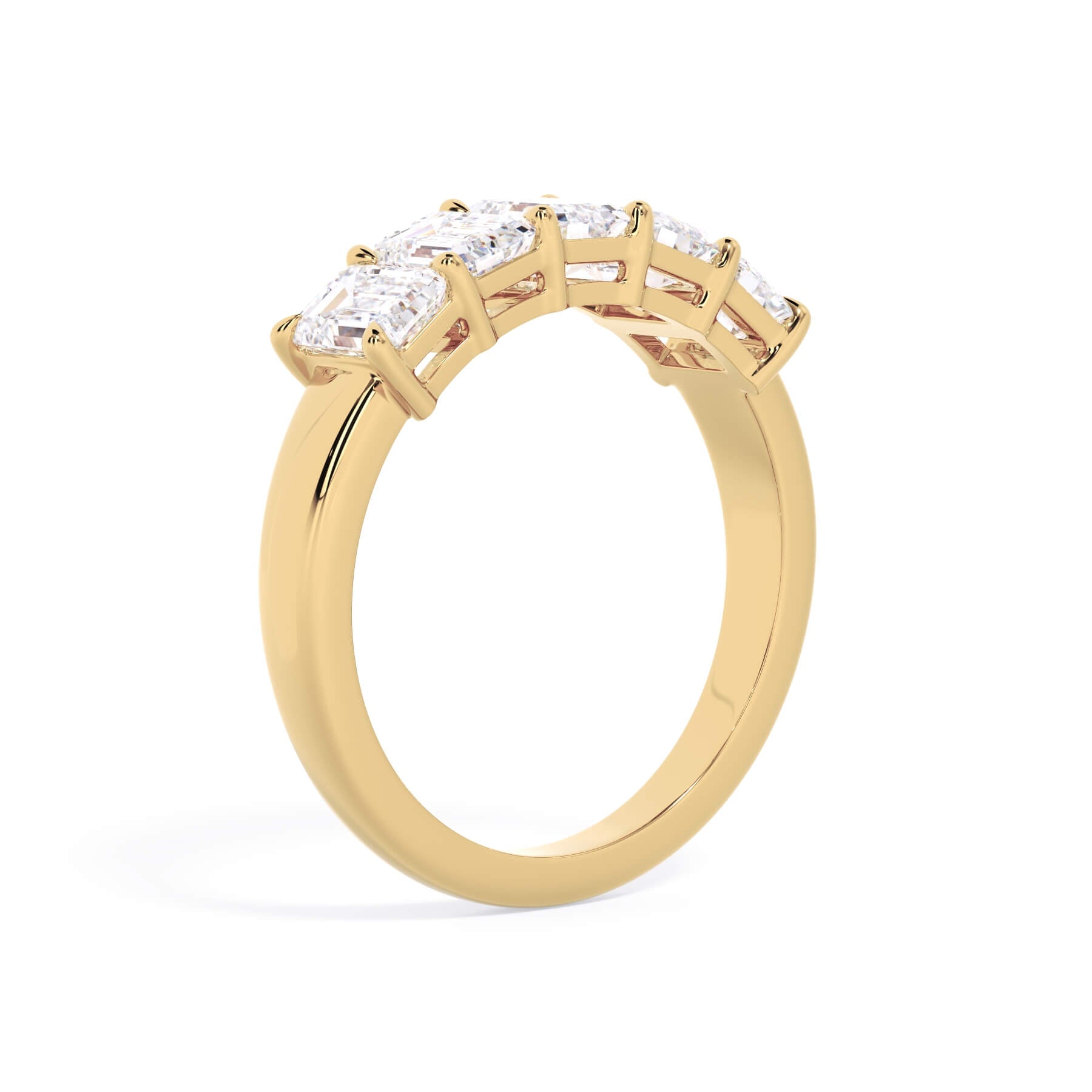 A picture of a five stone diamond wedding ring with emerald cut diamonds that are shared prong set in yellow gold on a white background with a slightly angled, through the finger view.