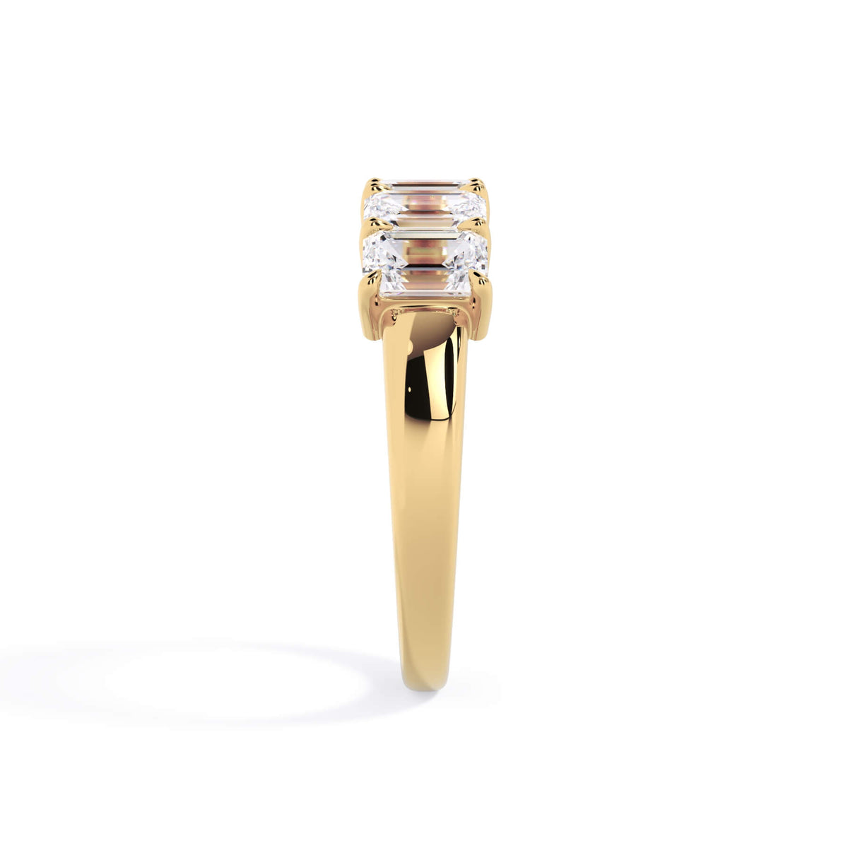 A picture of a five stone diamond wedding ring with emerald cut diamonds that are shared prong set in yellow gold on a white background with a side profile view.