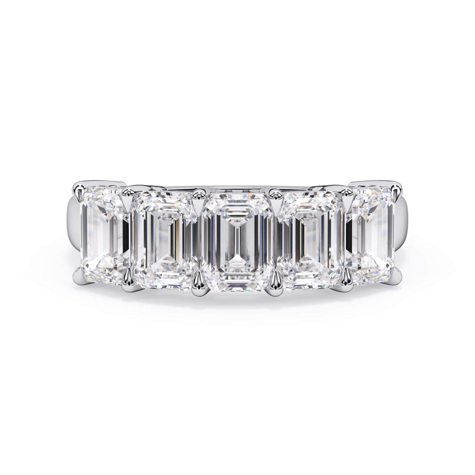 A picture of a five stone diamond wedding ring with emerald cut diamonds that are shared prong set in white gold or platinum on a white background with the ring facing forward, lying down.