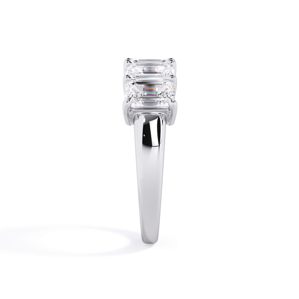 A picture of a five stone diamond wedding ring with emerald cut diamonds that are shared prong set in white gold or platinum on a white background with a side profile view.