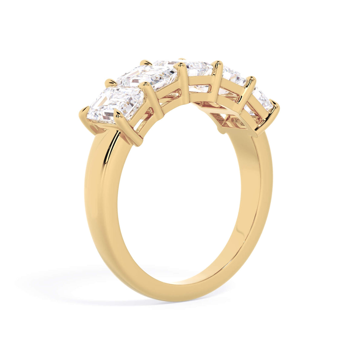 A picture of a five stone diamond wedding ring with emerald cut diamonds that are shared prong set in yellow gold on a white background with a slightly angled, through the finger view.