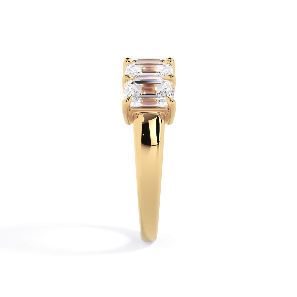 A picture of a five stone diamond wedding ring with emerald cut diamonds that are shared prong set in yellow gold on a white background with a side profile view.