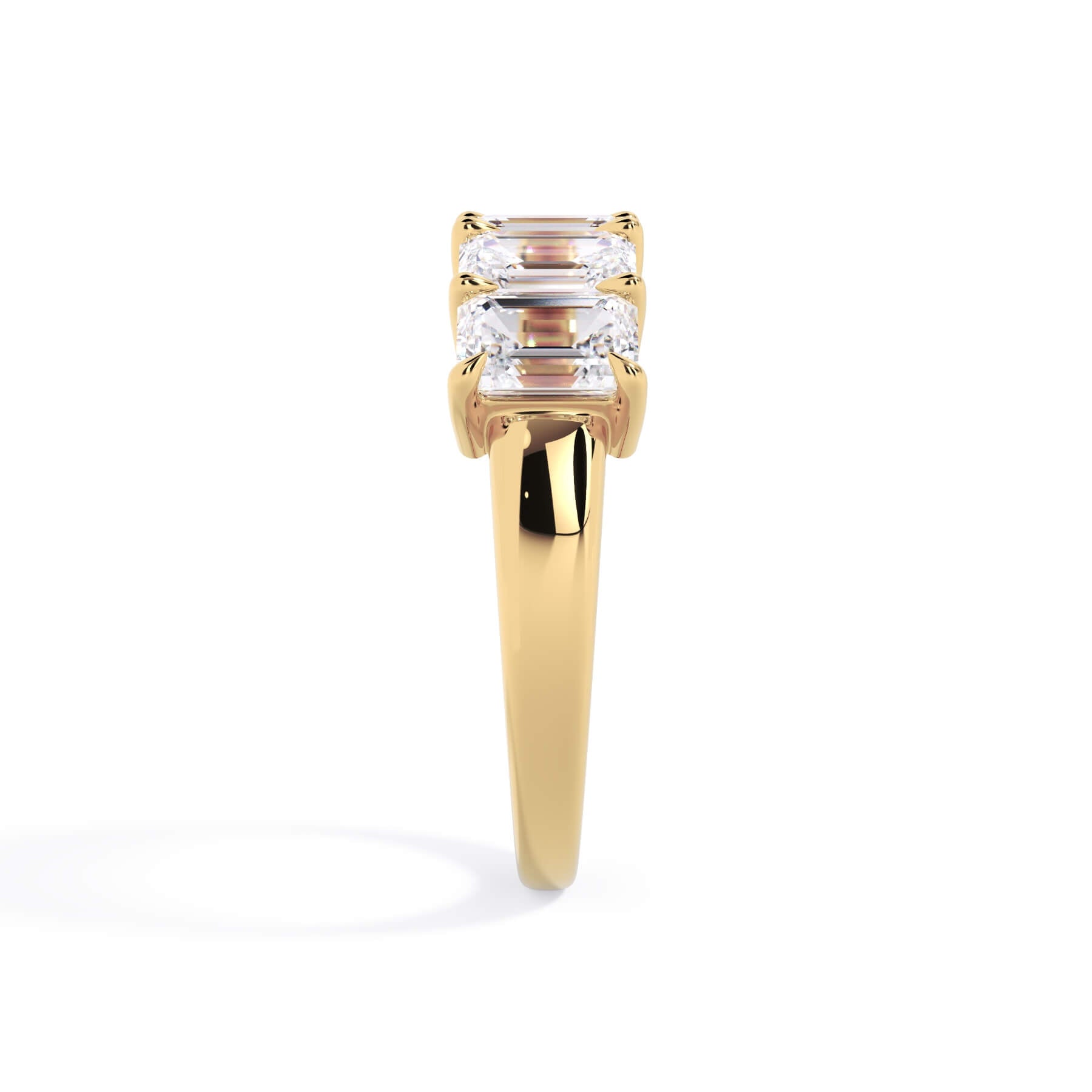 A picture of a five stone diamond wedding ring with emerald cut diamonds that are shared prong set in yellow gold on a white background with a side profile view.