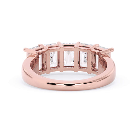 A picture of a five stone diamond wedding ring with emerald cut diamonds that are shared prong set in rose gold on a white background with a view of the underside of the ring.