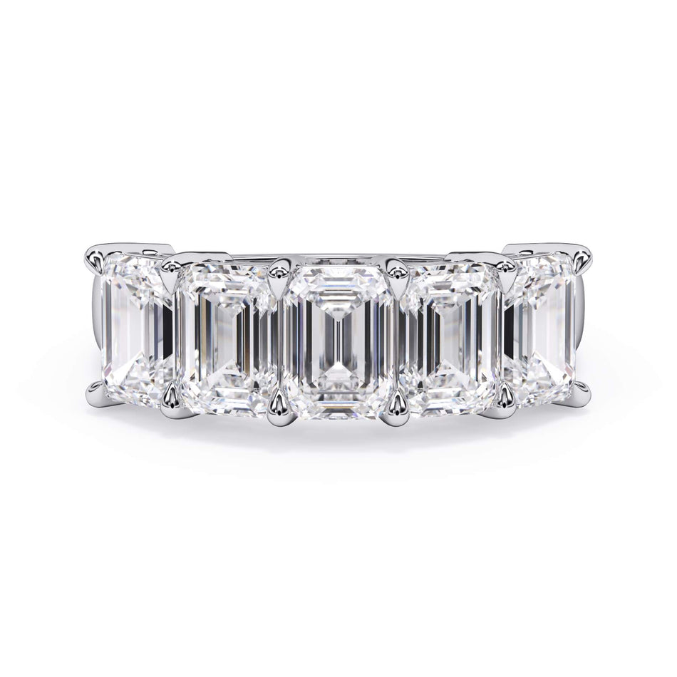 A picture of a five stone diamond wedding ring with emerald cut diamonds that are shared prong set in white gold or platinum on a white background with the ring facing forward, lying down.