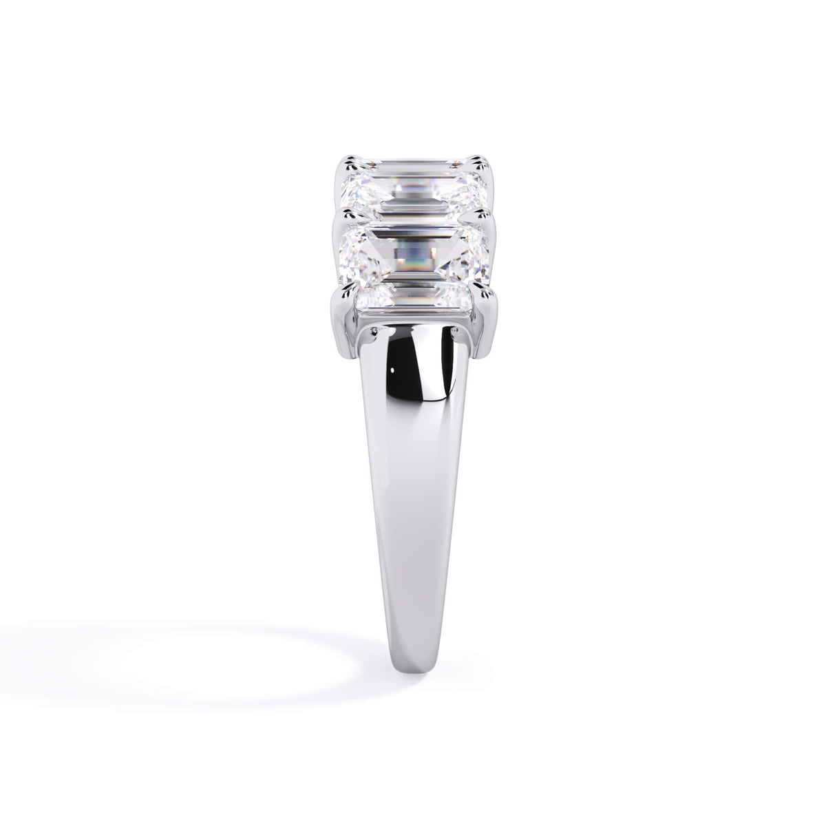 A picture of a five stone diamond wedding ring with emerald cut diamonds that are shared prong set in white gold or platinum on a white background with a side profile view.