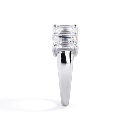 A picture of a five stone diamond wedding ring with emerald cut diamonds that are shared prong set in white gold or platinum on a white background with a side profile view.