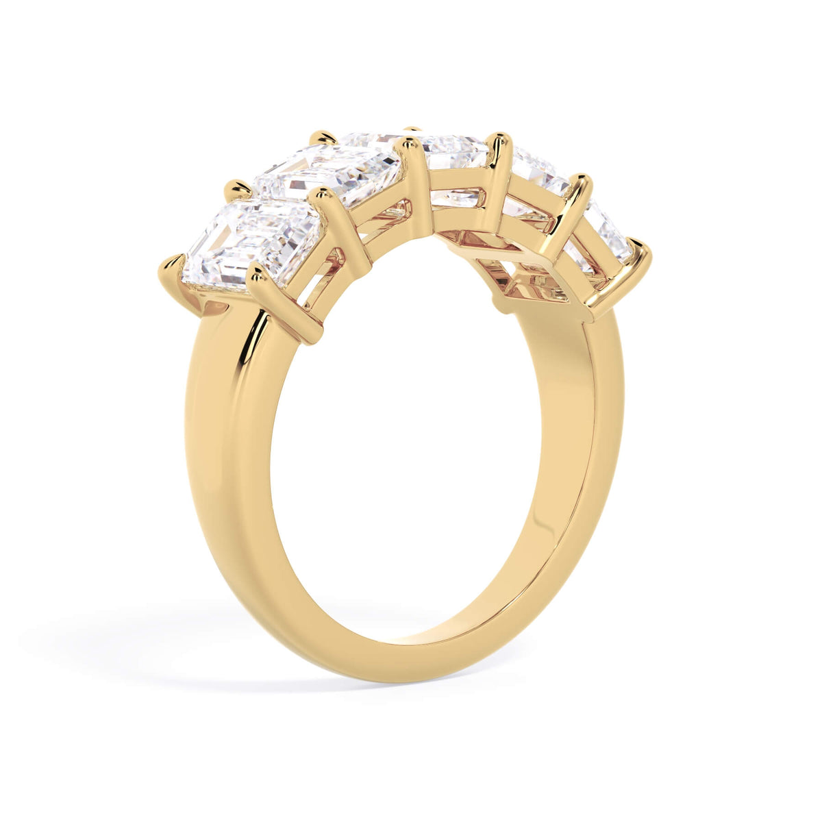 A picture of a five stone diamond wedding ring with emerald cut diamonds that are shared prong set in yellow gold on a white background with a slightly angled, through the finger view.