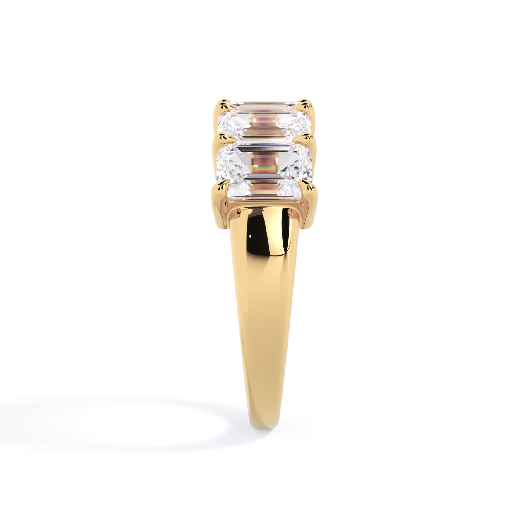 A picture of a five stone diamond wedding ring with emerald cut diamonds that are shared prong set in yellow gold on a white background with a side profile view.