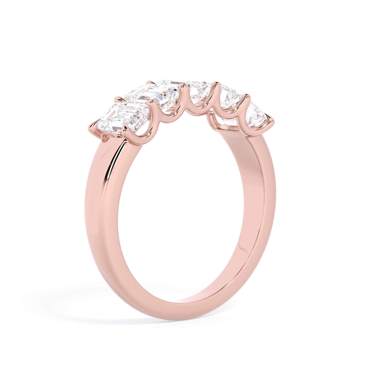 A picture of a five stone diamond wedding ring with emerald cut diamonds that are u prong set in rose gold on a white background with a slightly angled, through the finger view.