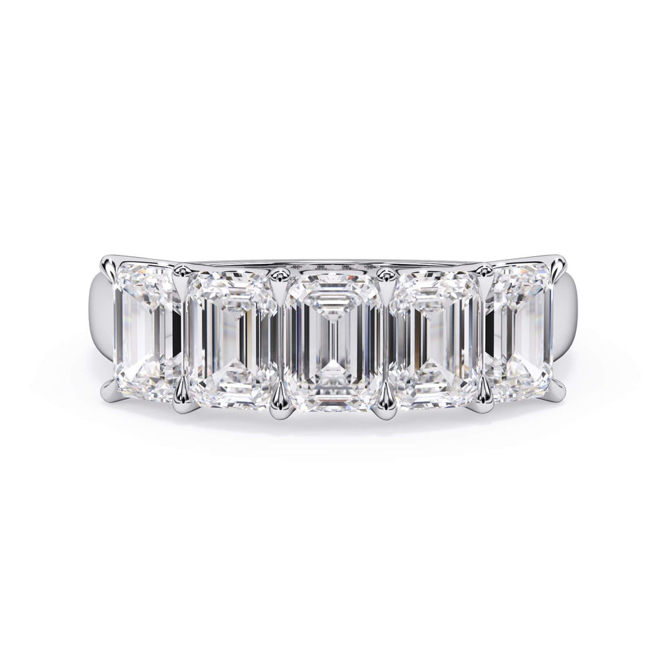 A picture of a five stone diamond wedding ring with emerald cut diamonds that are u prong set in white gold or platinum on a white background with the ring facing forward, lying down.