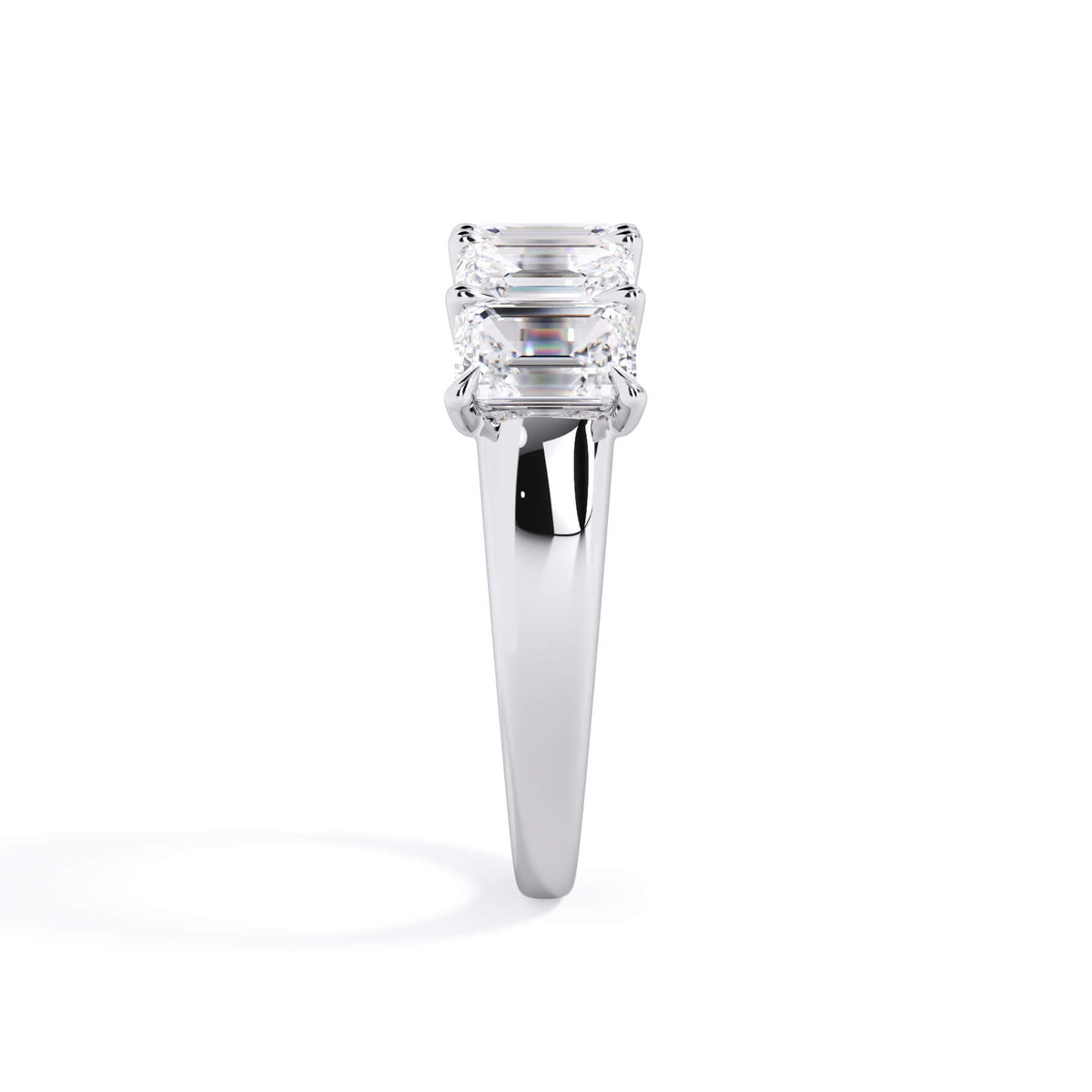 A picture of a five stone diamond wedding ring with emerald cut diamonds that are u prong set in white gold or platinum on a white background with a side profile view.