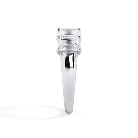 A picture of a five stone diamond wedding ring with emerald cut diamonds that are u prong set in white gold or platinum on a white background with a side profile view.