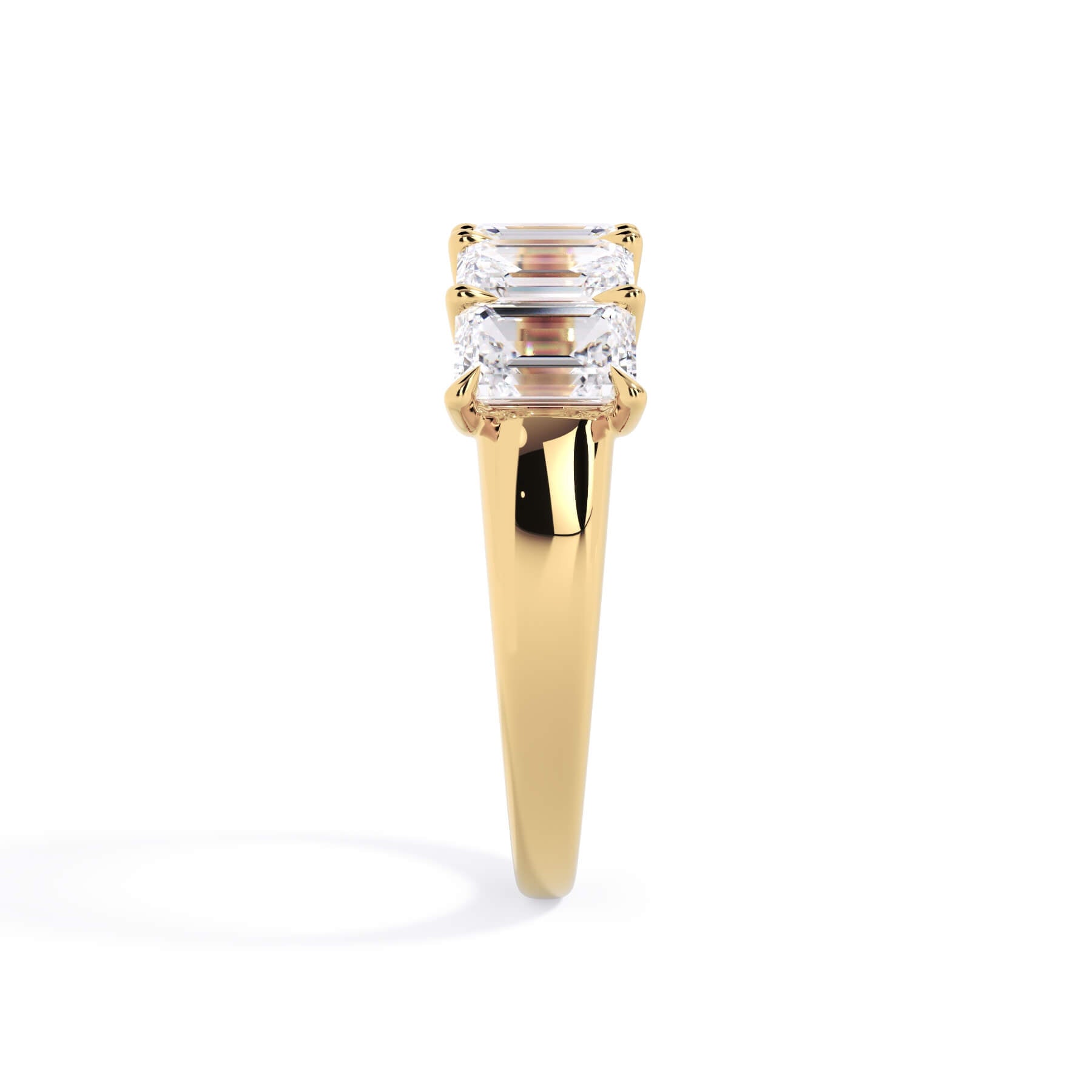 A picture of a five stone diamond wedding ring with emerald cut diamonds that are u prong set in yellow gold on a white background with a side profile view.