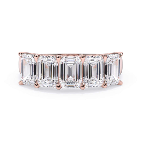 A picture of a five stone diamond wedding ring with emerald cut diamonds that are u prong set in rose gold on a white background with the ring facing forward, lying down.