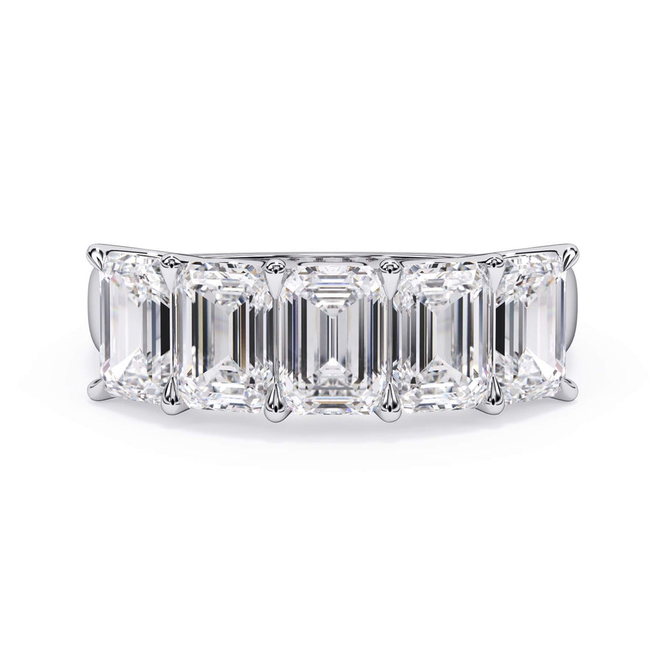 A picture of a five stone diamond wedding ring with emerald cut diamonds that are u prong set in white gold or platinum on a white background with the ring facing forward, lying down.