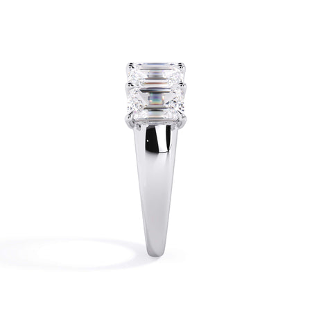 A picture of a five stone diamond wedding ring with emerald cut diamonds that are u prong set in white gold or platinum on a white background with a side profile view.