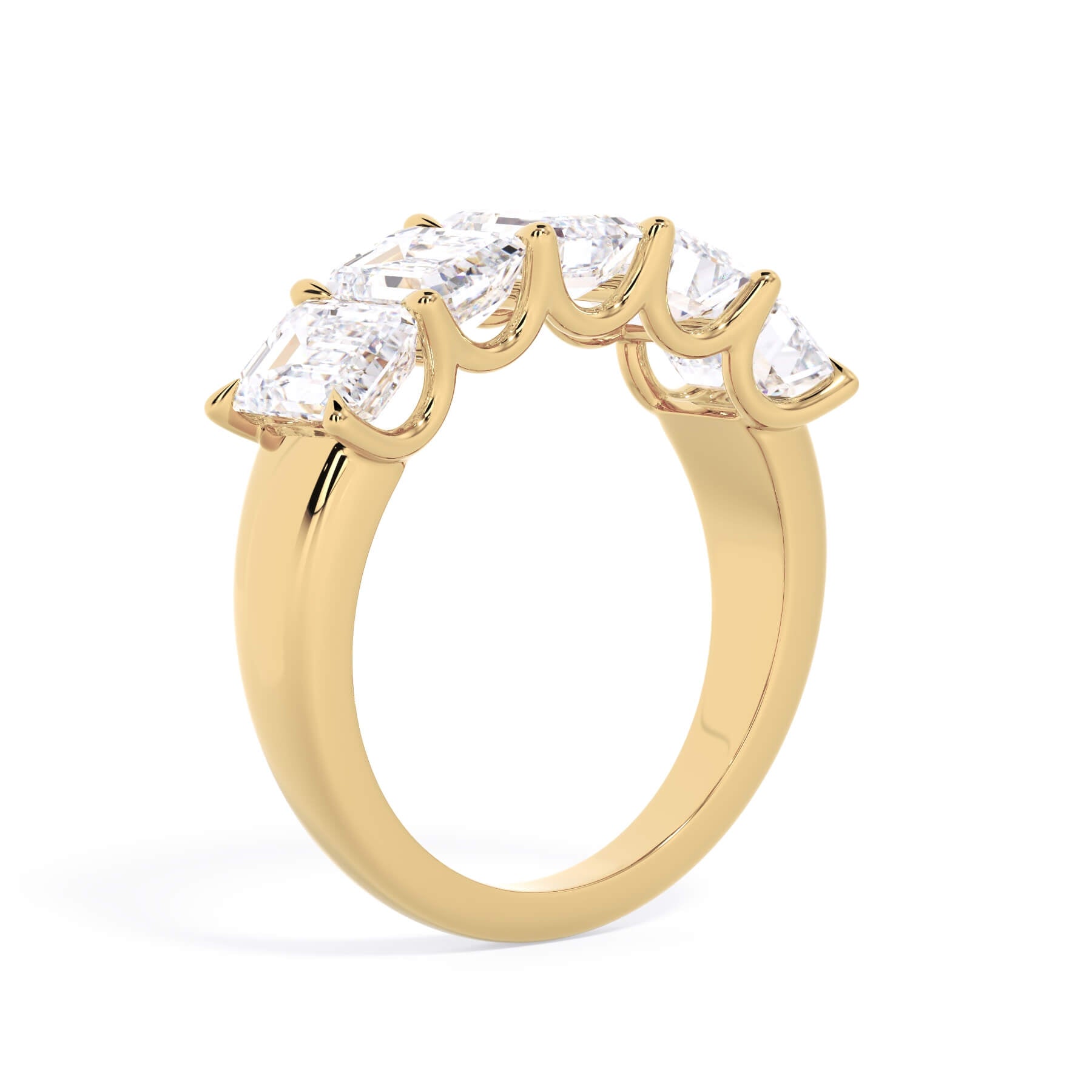 A picture of a five stone diamond wedding ring with emerald cut diamonds that are u prong set in yellow gold on a white background with a slightly angled, through the finger view.