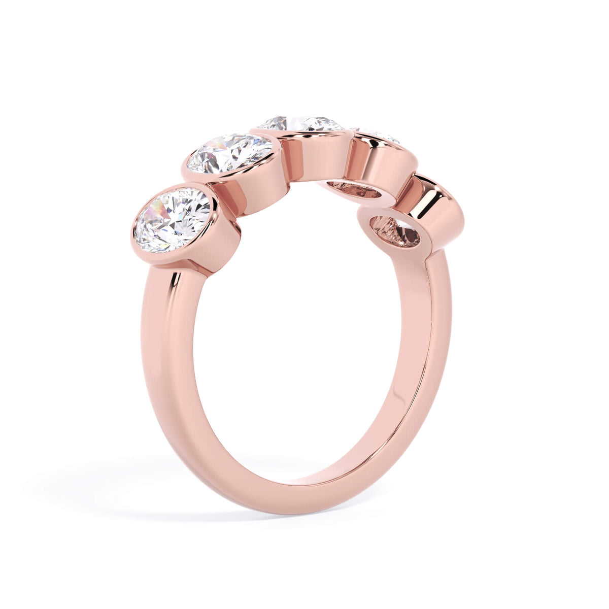 A picture of a five stone diamond wedding ring with oval shape diamonds that are bezel set in rose gold on a white background with a slightly angled, through the finger view.