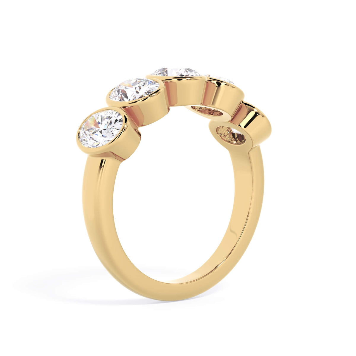 A picture of a five stone diamond wedding ring with oval shape diamonds that are bezel set in yellow gold on a white background with a slightly angled, through the finger view.