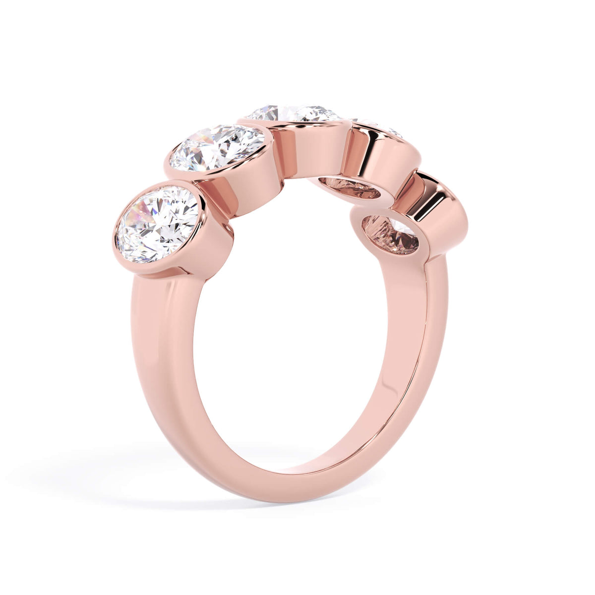 A picture of a five stone diamond wedding ring with oval shape diamonds that are bezel set in rose gold on a white background with a slightly angled, through the finger view.