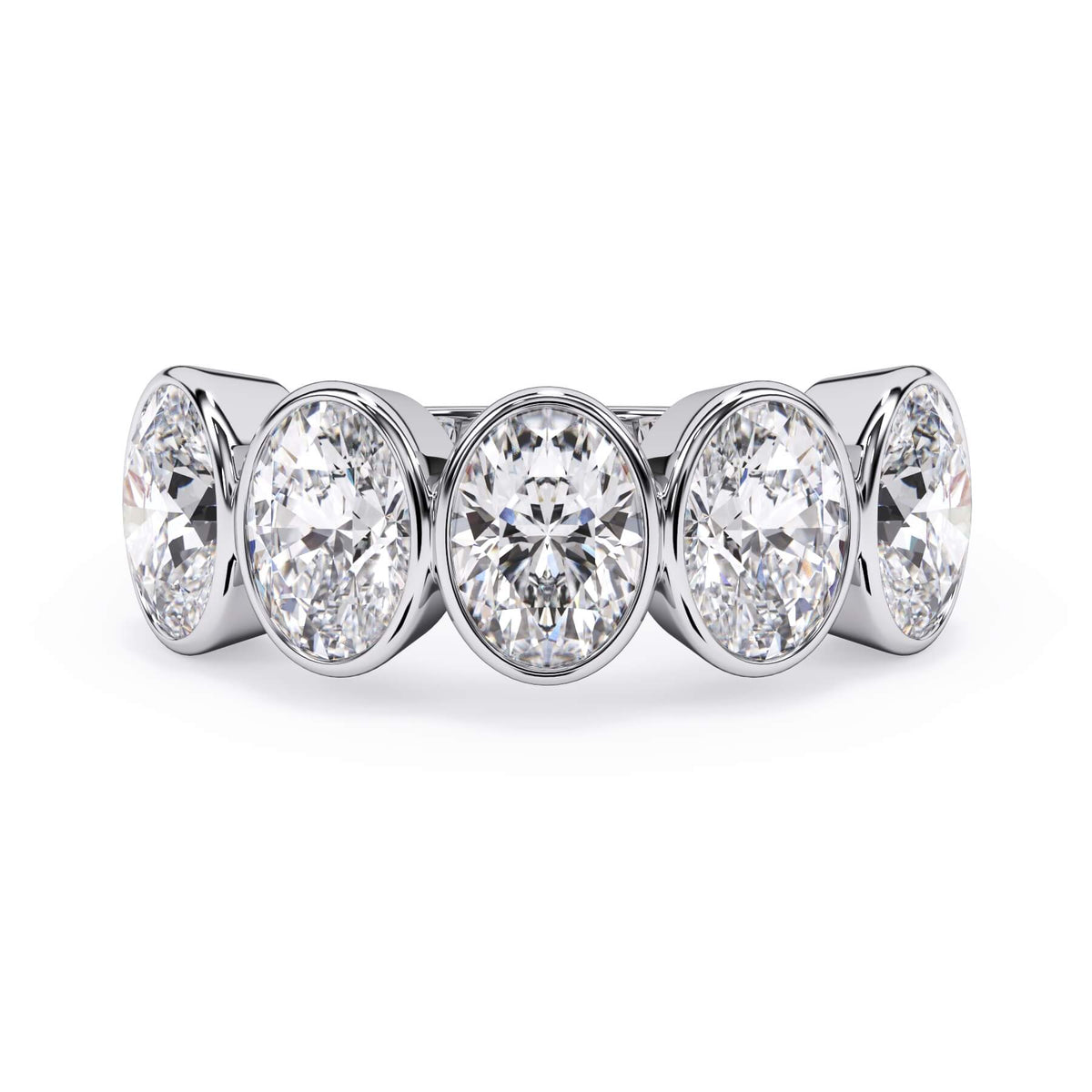 A picture of a five stone diamond wedding ring with oval shape diamonds that are bezel set in white gold or platinum on a white background with the ring facing forward, lying down.
