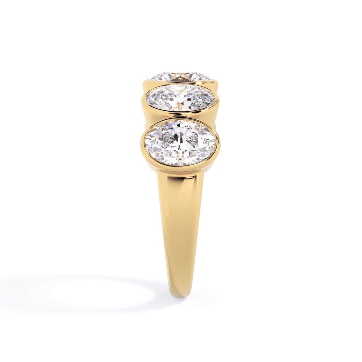 A picture of a five stone diamond wedding ring with oval shape diamonds that are bezel set in yellow gold on a white background with a side profile view.