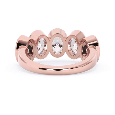 A picture of a five stone diamond wedding ring with oval shape diamonds that are bezel set in rose gold on a white background with a view of the underside of the ring.