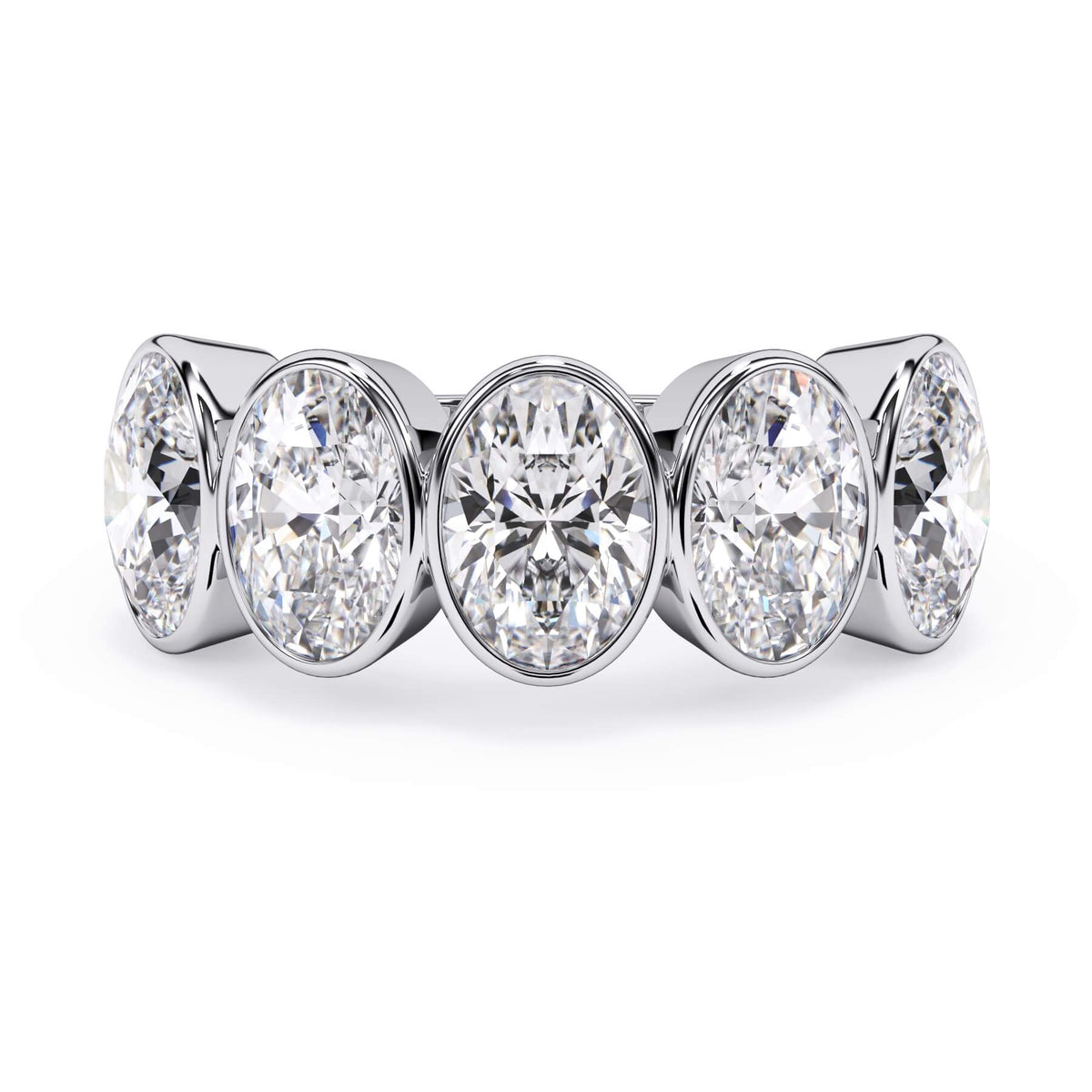 A picture of a five stone diamond wedding ring with oval shape diamonds that are bezel set in white gold or platinum on a white background with the ring facing forward, lying down.