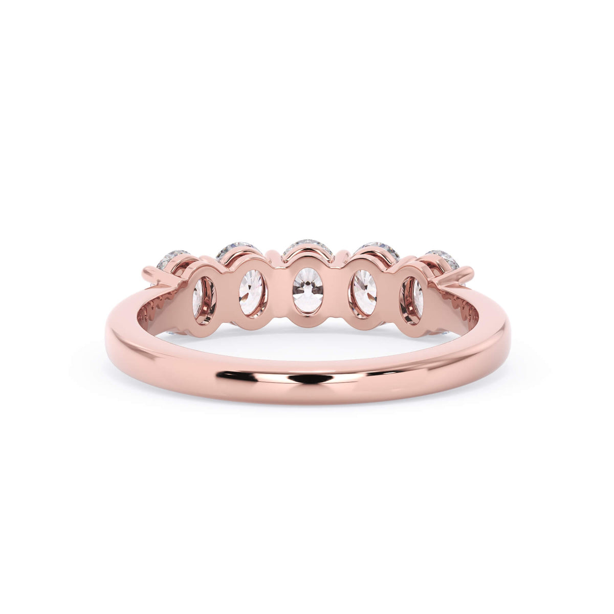 A picture of a five stone diamond wedding ring with oval shape diamonds that are shared prong set in rose gold on a white background with a view of the underside of the ring.