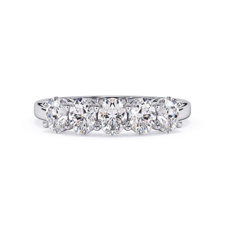 A picture of a five stone diamond wedding ring with oval shape diamonds that are shared prong set in white gold or platinum on a white background with the ring facing forward, lying down.