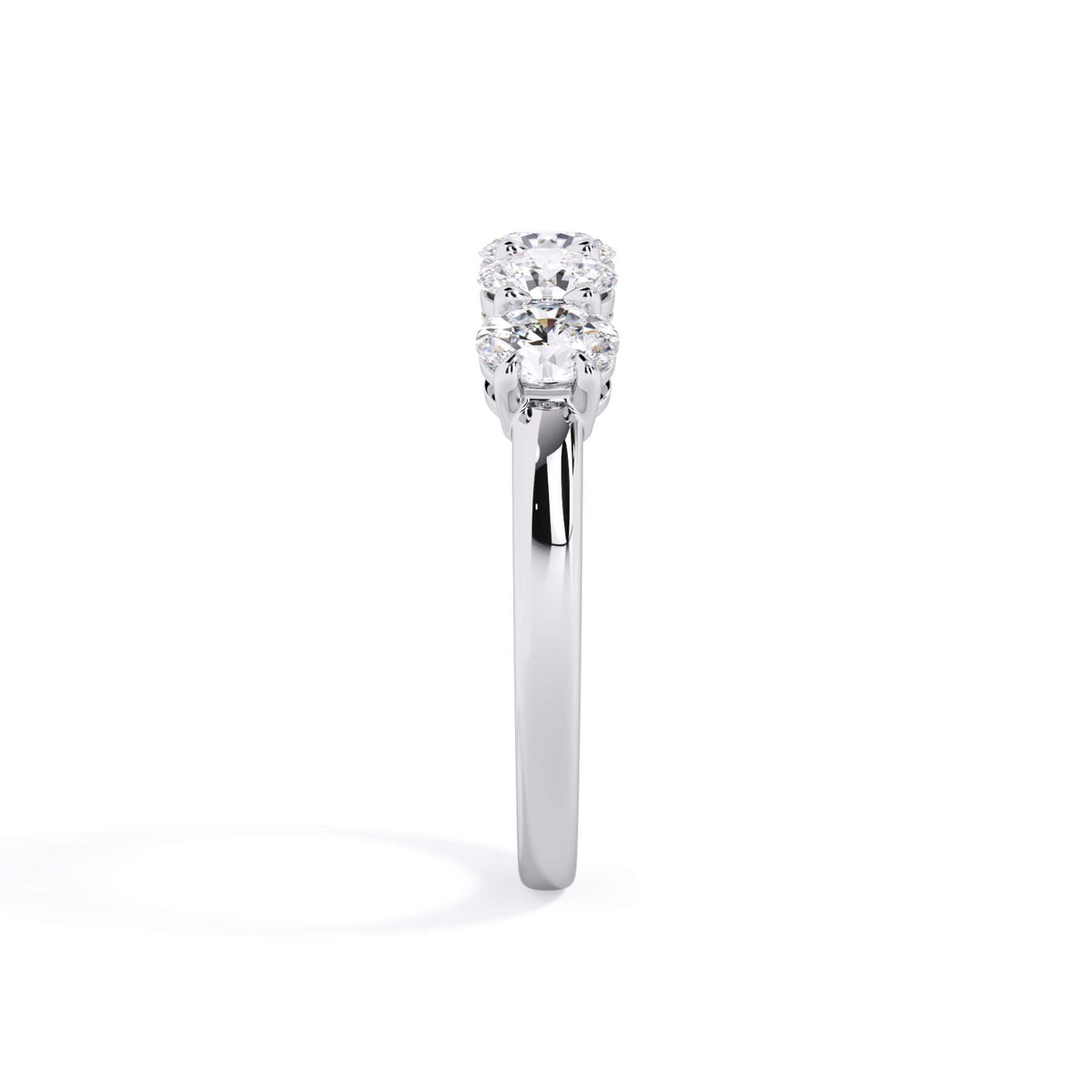 A picture of a five stone diamond wedding ring with oval shape diamonds that are shared prong set in white gold or platinum on a white background with a side profile view.