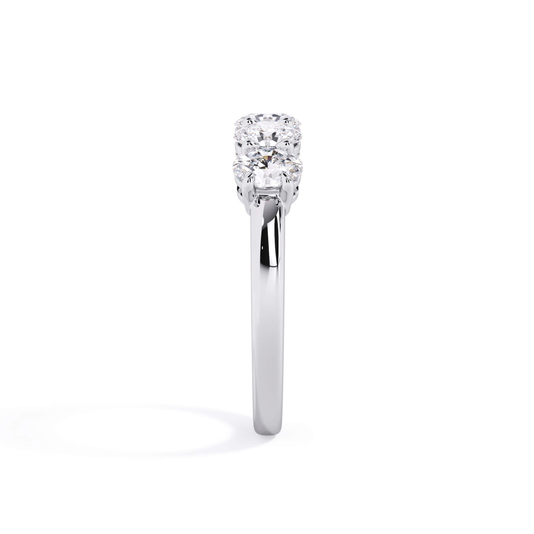 A picture of a five stone diamond wedding ring with oval shape diamonds that are shared prong set in white gold or platinum on a white background with a side profile view.