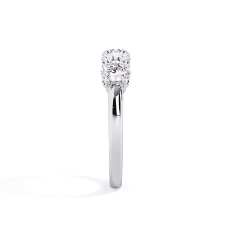 A picture of a five stone diamond wedding ring with oval shape diamonds that are shared prong set in white gold or platinum on a white background with a side profile view.