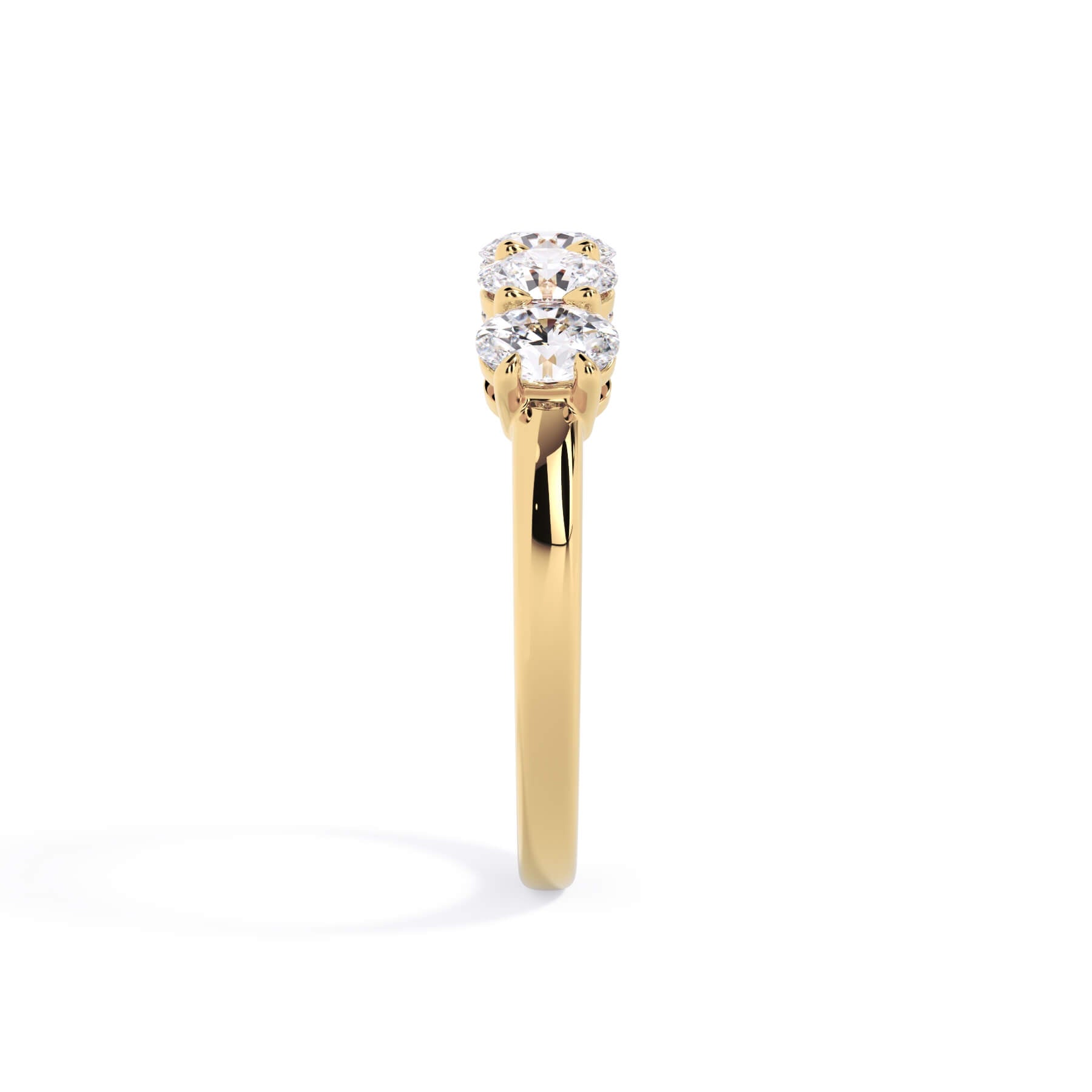 A picture of a five stone diamond wedding ring with oval shape diamonds that are shared prong set in yellow gold on a white background with a side profile view.