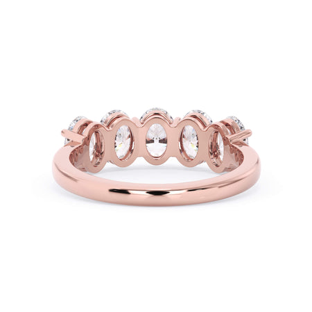 A picture of a five stone diamond wedding ring with oval shape diamonds that are shared prong set in rose gold on a white background with a view of the underside of the ring.